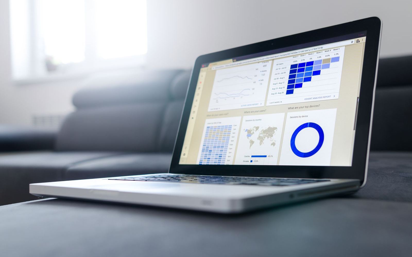 A laptop displaying an analytics dashboard with charts and a progress ring